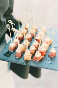 Close-up of skewered appetizers on a slate platter, ideal for elegant gatherings.